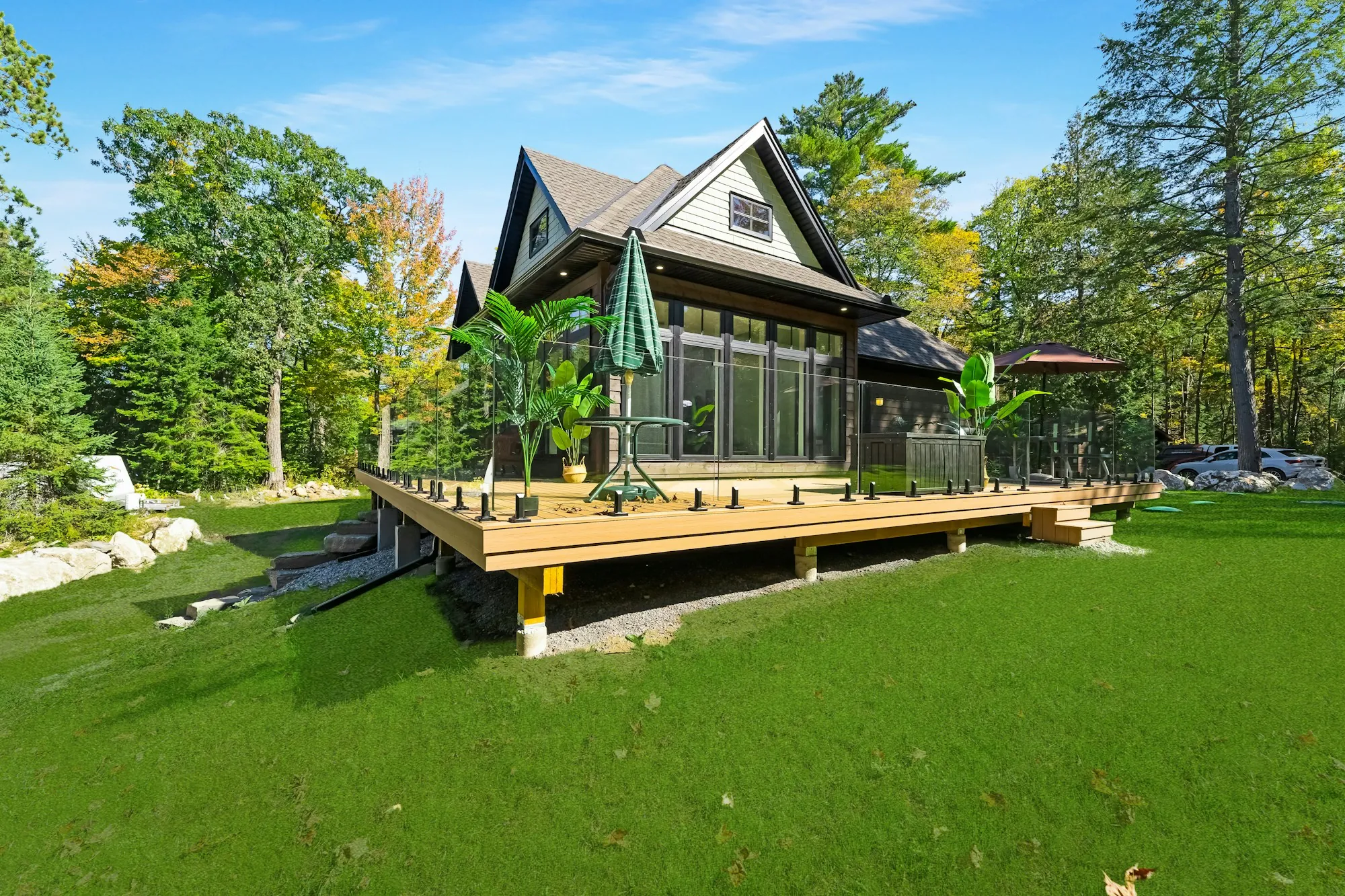 Wood-sided cottage with a wide deck on a wooded lot